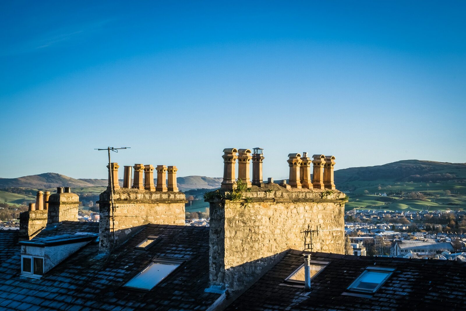 Slate rooftops and stone chimney stacks across a UK town